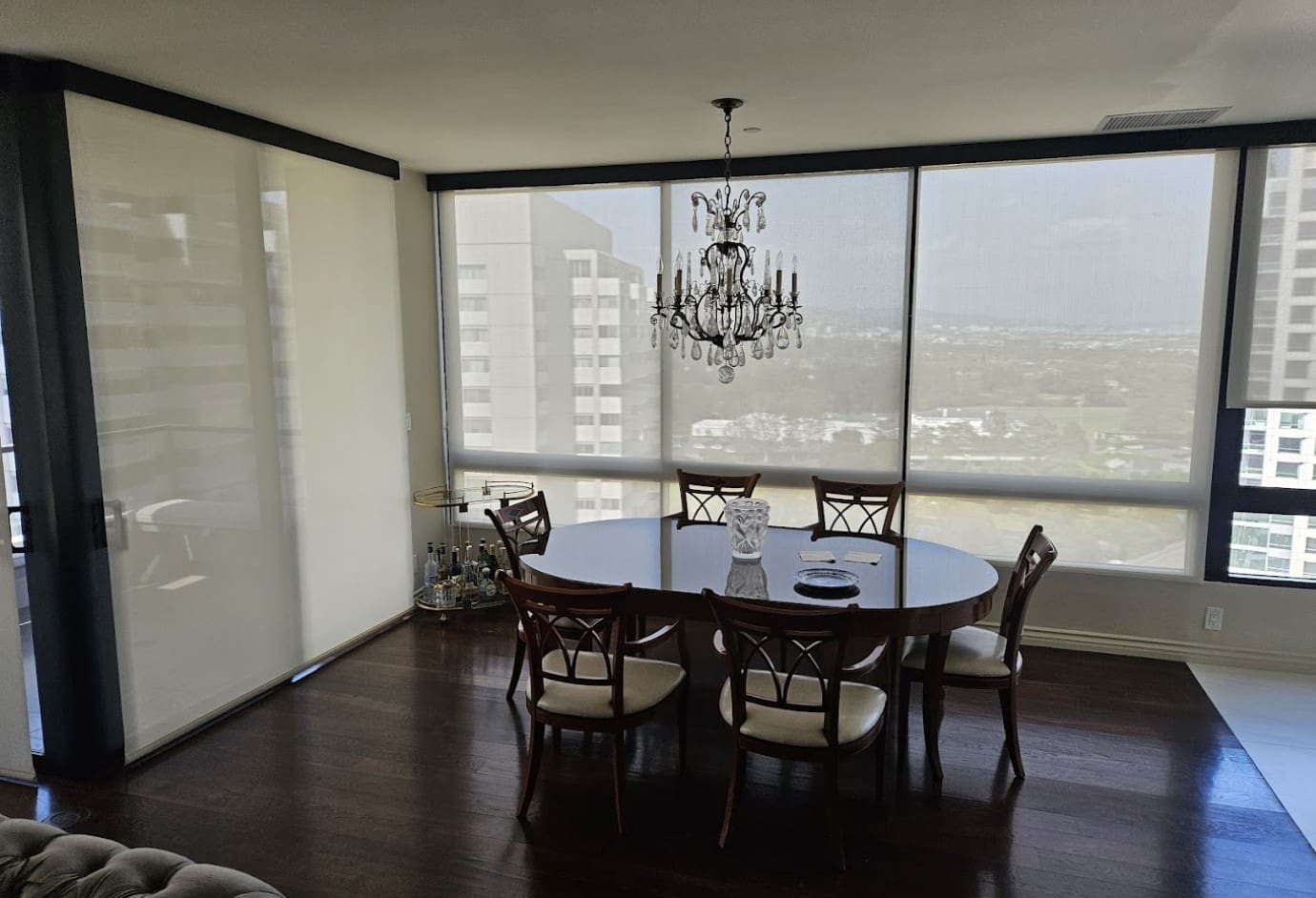 A dining room table with chairs and a chandelier.